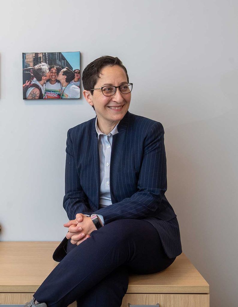 Stacey Harris, Boston University associate director of Disability & Access Services, sitting on a cabinet