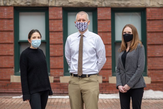 A photo of Sarah Gordon, Paul Shafer, and Megan Cole Brahim standing next to one another wearing masks