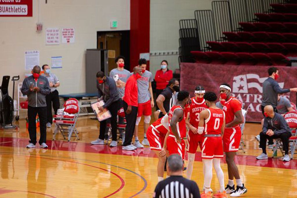 A photo of the BU men's basketball team in a huddle on the court