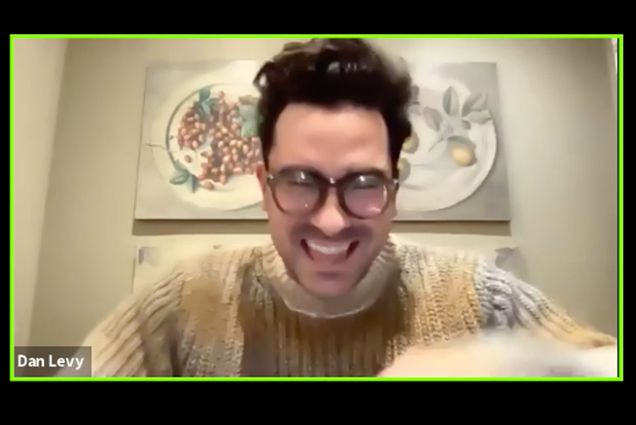 Screenshot of Schitt’s Creek cocreator, showrunner, and star Dan Levy, smiles widely and moves his head towards the camera. He wears large glasses and a thick grayish tan sweater. The picture is a bit blurry. Screenshot taken during a zoom event on Friday February 19th for BU students.