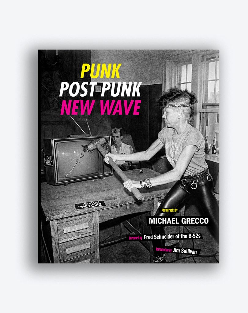 Photo of the book cover of "Punk Post Punk New Wave" by Michael Grecco. The cover has a black and white photo of a young person smashing a TV screen with a hammer.