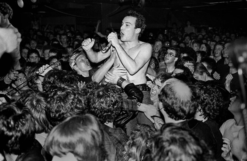 Black and white photo of Jello Biafra of Dead Kennedys crowd-surfing during a show at the Channel.
