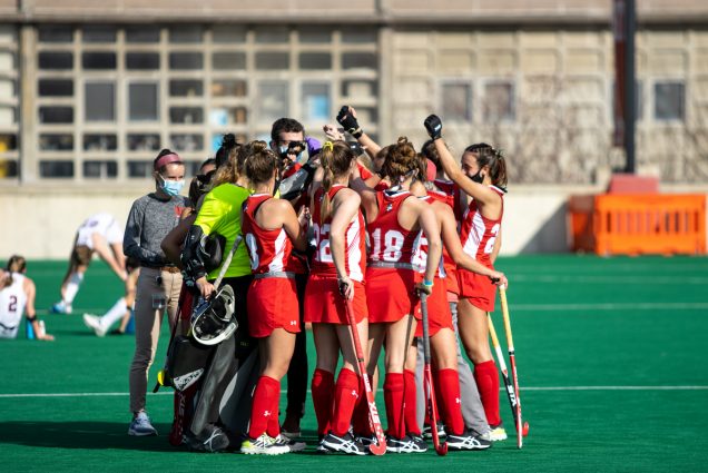 A photo of the BU Field Hockey Team in a huddle on the field