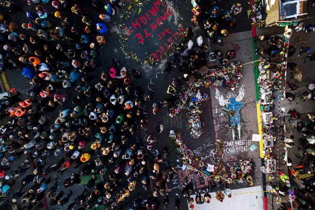 Aerial photo of a crowding gathers next to the spot where George Floyd was murdered at George Floyd Square after a guilty verdict was announced at the trial of former Minneapolis police Officer Derek Chauvin. In the photo, many people are seen from above, as well as a mural painted on the ground that says “I Can’t Breathe, I Can’t Breathe” below a blue painting of Floyd as an angel. At the top, painting on the street reads “Justice for Daunte Wright”