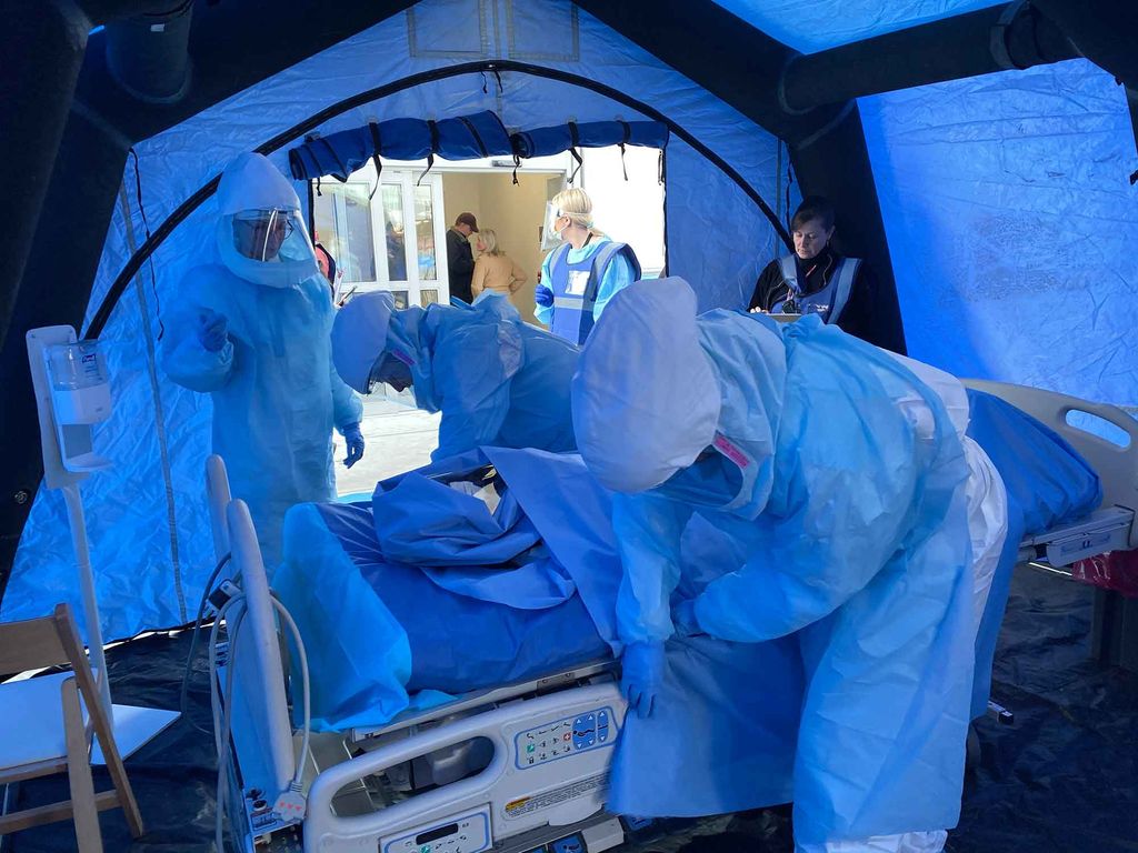 Members of the Boston Medical Center Special Pathogens Unit (SPU) perform a training exercise in hazmat suits