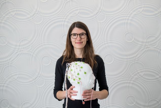 A portrait photograph of Laura Lew holding a model head