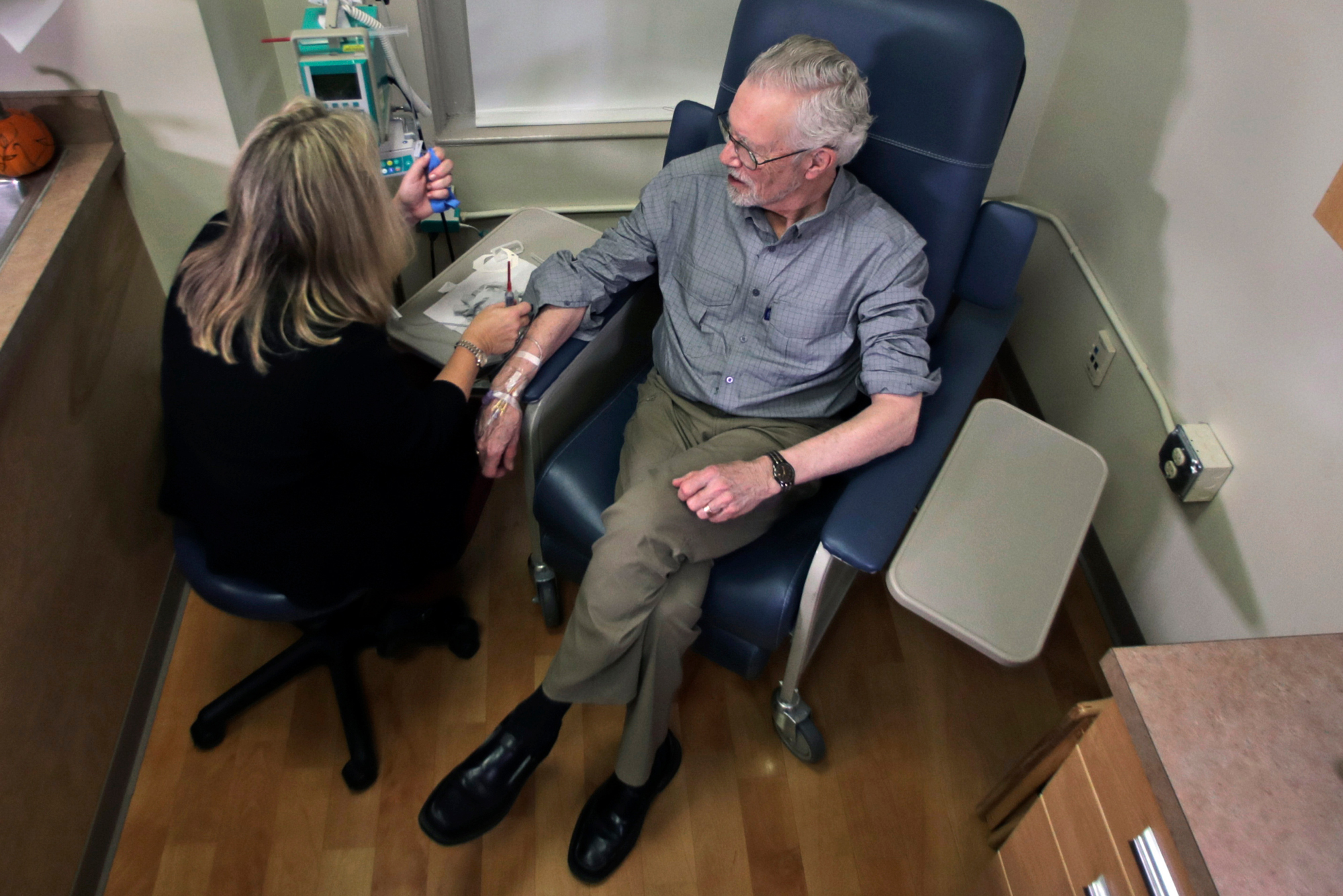 In this November 2019 photo, Charles Flagg, who has Alzheimer's disease, sits for an infusion while participating in a study on the drug aducanumab at Butler Hospital in Providence, R.I. Biogen says it can slow the decline of Alzheimer's disease, the most common form of dementia.
