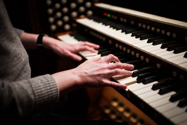 a photo focused on Justin Blackwell's fingers on the keys of the organ at Marsh Chapel as he practices.