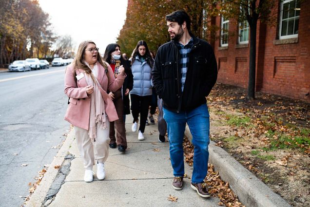 Photo of Executive Director of Downtown Framingham, Inc. Anthony Lucivero talking with Sargent College lecturer, Kaytlin Eldred, MPH as they tour downtown Framingham on November 17, 2021. Lucivero wears a black jacket and Eldred wears a pink jacket.