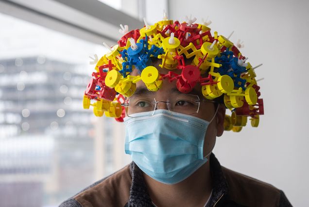 Photo of PhD student Ke Wu wearing a magnetic Metamaterial device. The hat is made of materials in red, yellow, and blue.