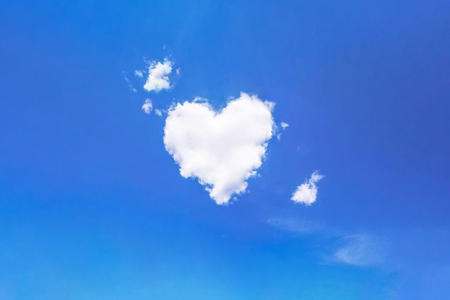 photo of a white, heart shaped cloud in a blue sky.