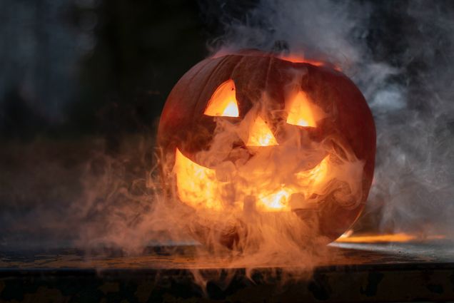 Photo: A smiling jack-o-lantern shown in a dark room. "Spooky" fog highlights the scene.