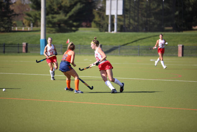 Photo: Terriers field hockey topped Bucknell 2-1 on October 30 to claim their sixth Patriot league regular season title in eight years. Three BU field hockey players run down field with sticks at the ready as a Bucknell field hockey player stands to defend in front of them.