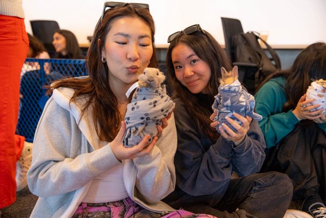 Photo: Two young college students, Stephanie Kung (COM’23), left, and Kelly Ye (QST’23) cuddle with bunnies on the 14th floor of CDS on Boston University's campus. “Barn Babies” brought a petting zoo to BU on April 20, where students signed up for time slots to snuggle with their choice of pig, goat, bunnies, chicks, or kittens. The room was filled with smiles and the cooing of baby animals from start to finish. Photo by Will Chapman COM (’26)