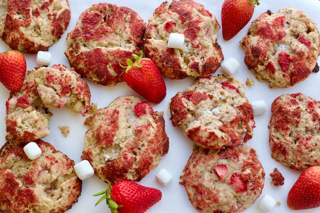 Photo: a dozen or more strawberry shortcake cookies, which are golden brown and have strawberries and minimarshmellows around the sides