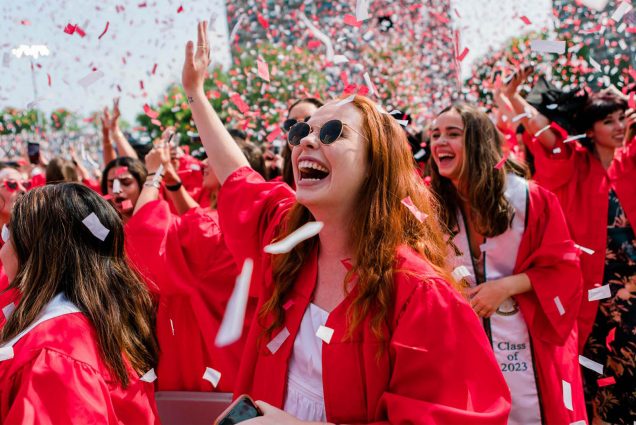 Photo: A large sea of graduates in red robes with black caps celebrate at the 150th Boston University Commencement