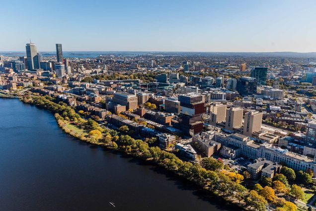 Photo: Aerial photography of the Boston University campus. University and city buildings are shown next to the scenic Charles River on a sunny day.