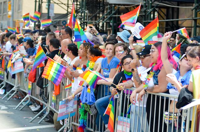 Photo: Spectators hold rainbow flag and cheer on the marchers as the Gay Pride Parade proceeds up Sixth Avenue in New York City on June 24, 2018.