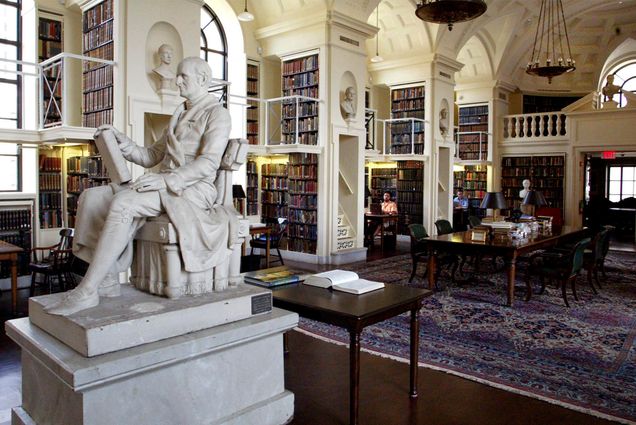 Photo: An ornate library with many books are wood/stone carvings