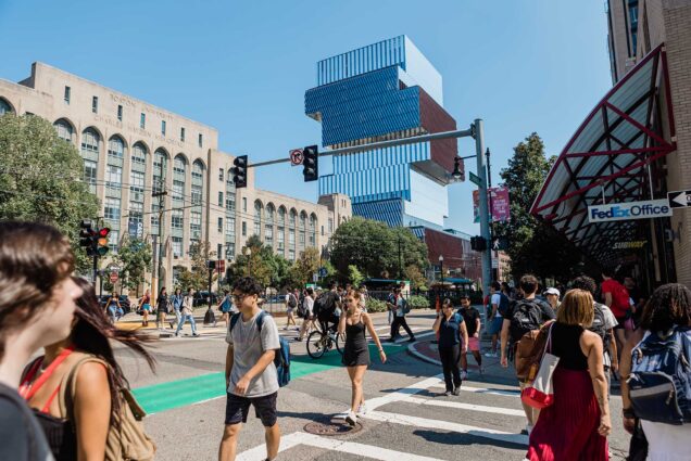 Photo: Stock photo of Boston University's campus. A glass, Jenga-like building can be seen looming over Commonwealth Ave. as students and pedestrians walk down BU's East campus.