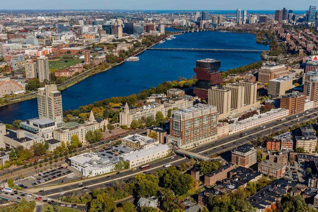 Photo: An overhead view of Boston University's campus on a sunny day. An urban mass of buildings along a river