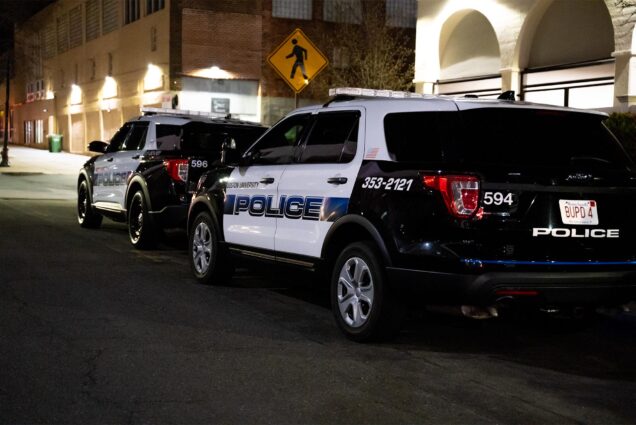 Photo: Two BU Police SUVs parked on an urban street at night