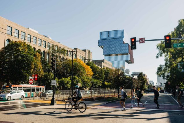 Photo: Stock photo of BU's campus during a sunny a day. The Center for computing and data sciences can be seen in the skyline in the distance as students and pedestrians cross Comm. Ave. in BU's Central Campus.