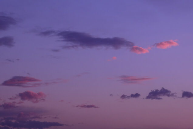 Photo: Shot of a purple and pink sunset. Clouds and sky are tinted a deep purple from the sunset.