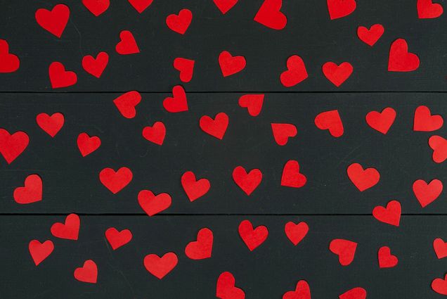 Photo: Stock image of black background with red hearts.