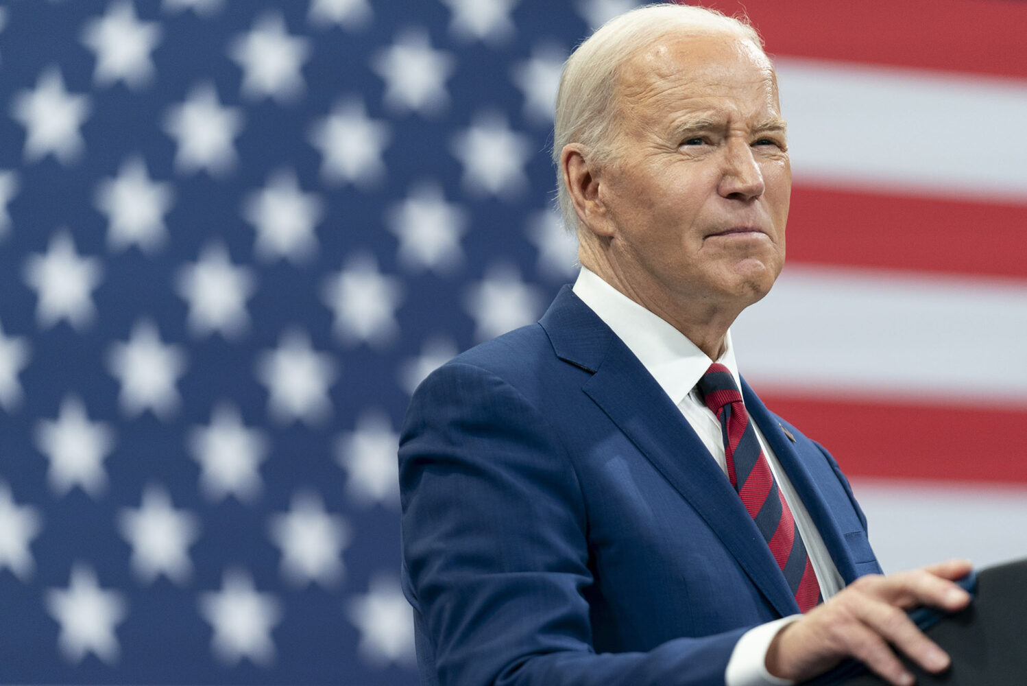 Photo: President Joe Biden delivers remarks during a campaign event with Vice President Kamala Harris in Raleigh, N.C. He stands in front of an American flag with a navy suit and red tie.