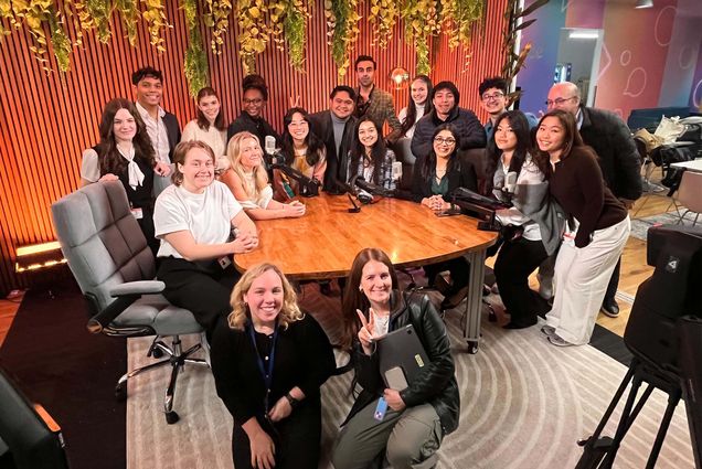 Photo: A large group of students and teachers gathered around a table