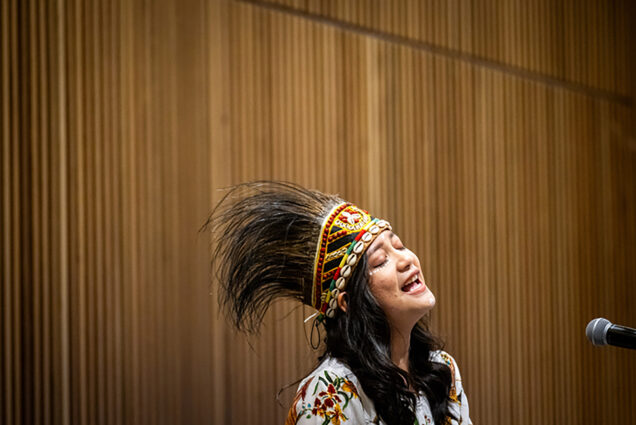 Photo: Sisilia Marpaung (CFA’25) sings a Biak song, followed by a Bahasa song of Indonesia while wearing a Papua crown during the Women of Color Circle's International Women's Day Celebration