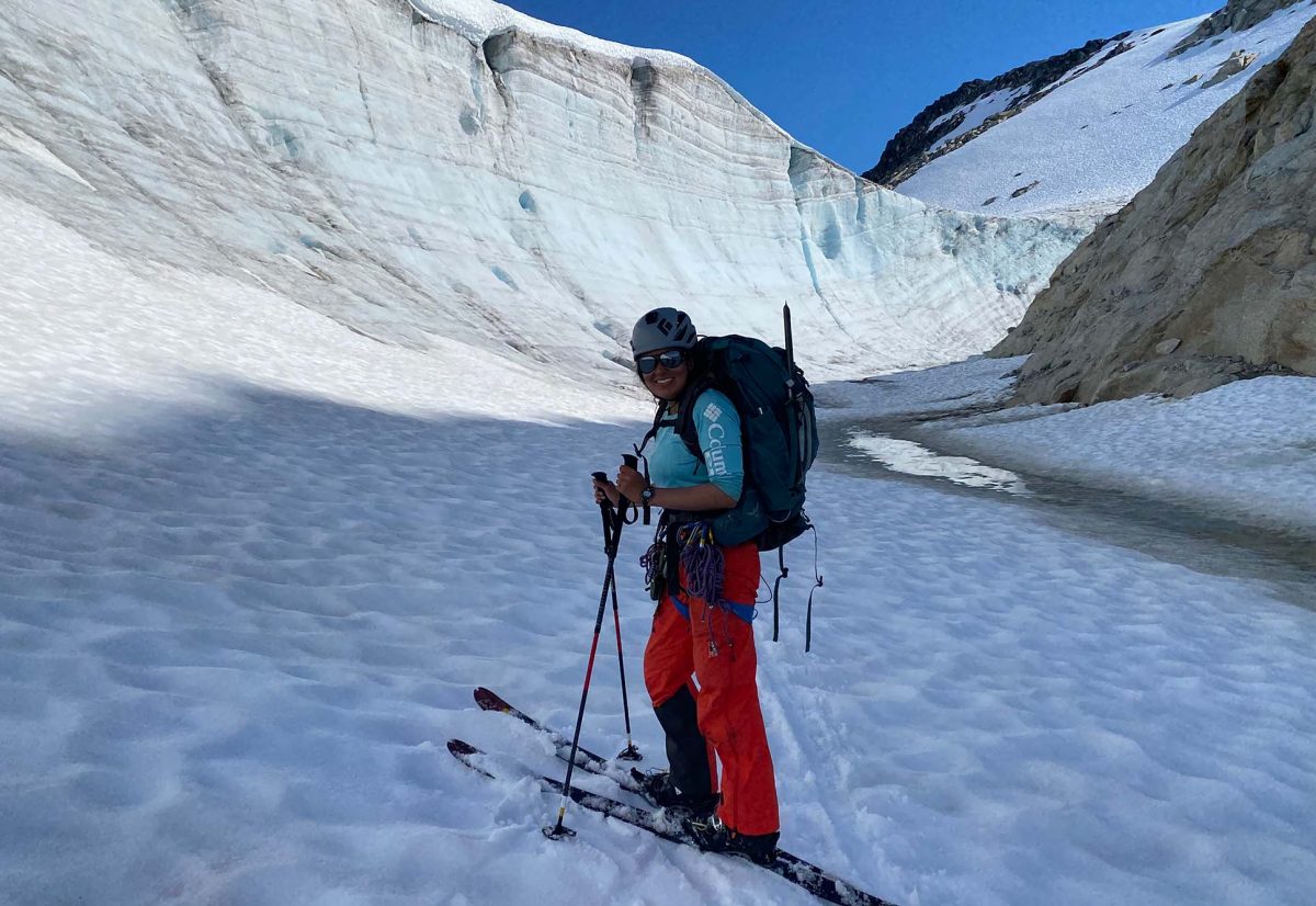 photo of Randall skiing in a place called Echo Glacier. She is between a glacier and a mountain, where the ice has melted around the sides.