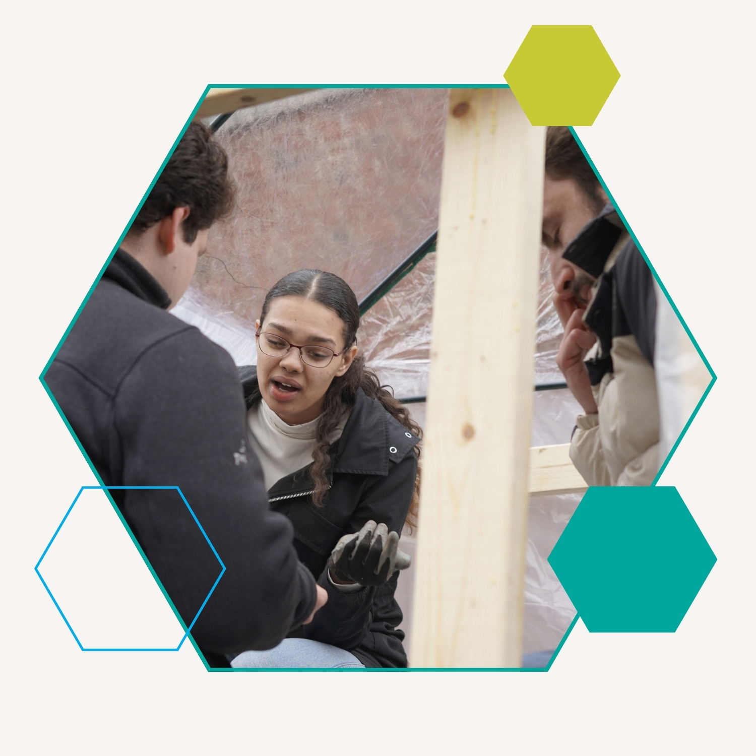 Students collaborate inside a wooden tented structure.