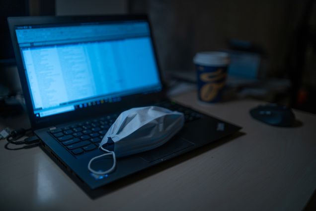 Medical face mask sitting on top of an open computer
