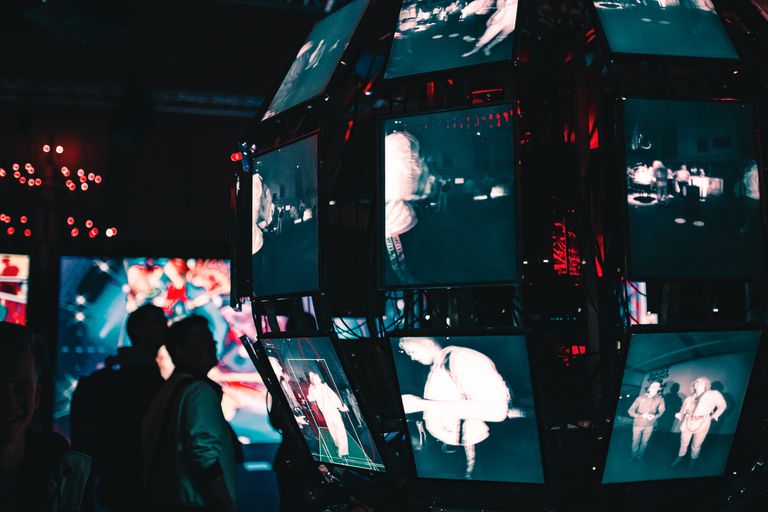 silhouettes of two figures gazing upon a larger than life digital installation of the earth