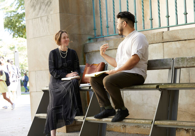 Associate Dean for Experiential Education Julie Dahlstrom works on a bench outside BU Law with student James Cho ('22)