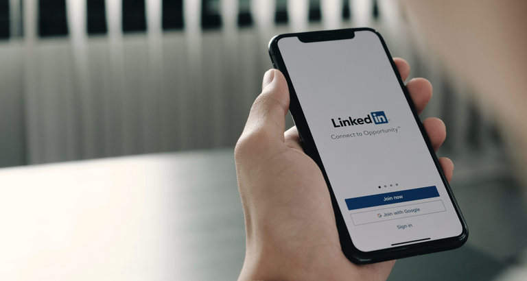 Person holding iPhone logging into Linkedin