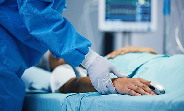 Doctor touches the hand of patient about to undergo surgery