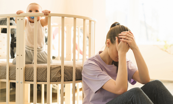 The mother is very tired, and the child does not want to fall asleep. Mom's trying to take a nap. The difficulties of motherhood, sleepless night. High quality photo