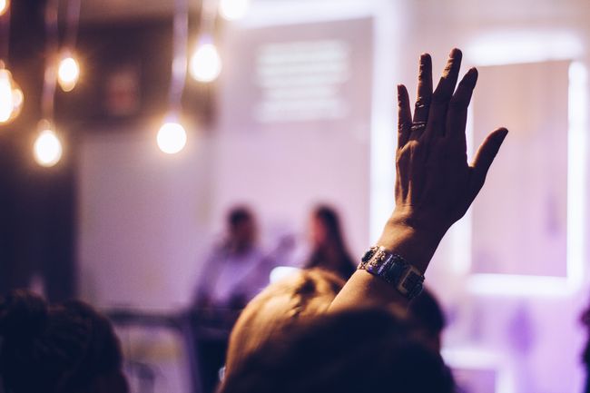 Audience member raises hand at indoor event