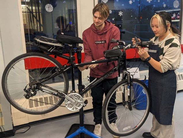 two students work together to tune up a bike together