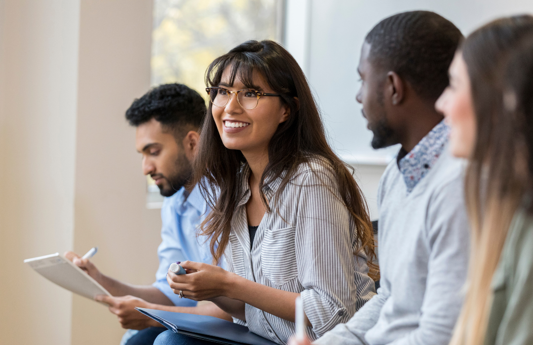 Female student with long brown hair looking forward as her classmates look at her