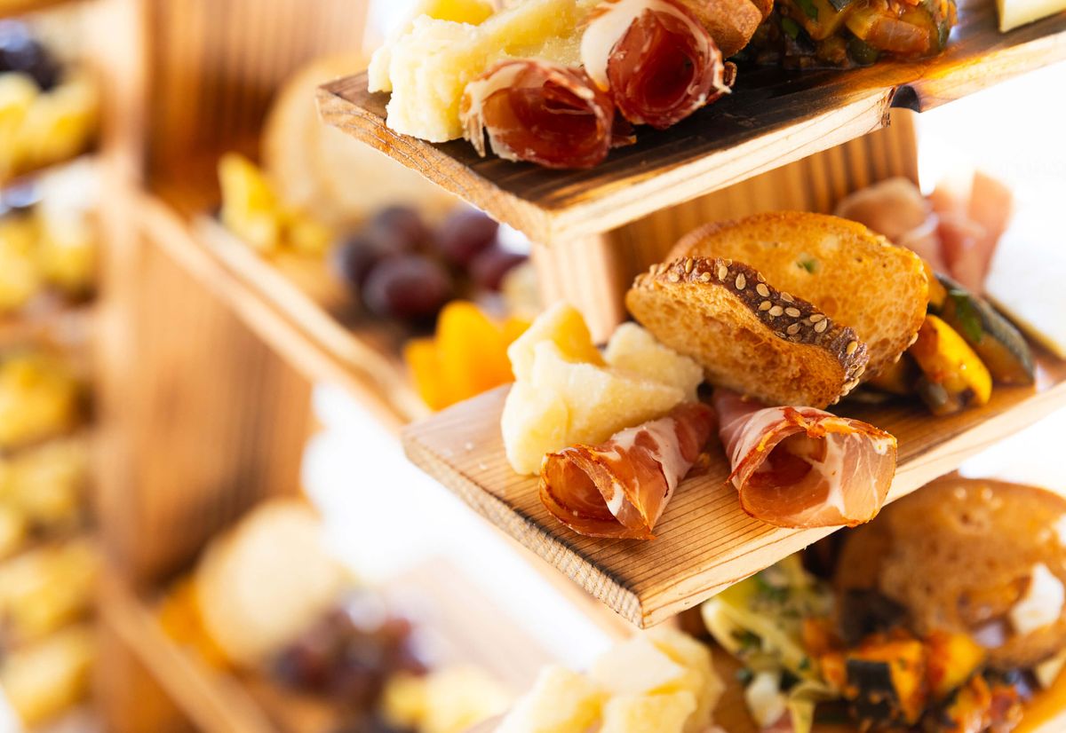 Individual charcuterie boards with cheese, meat, vegetable, and crostini