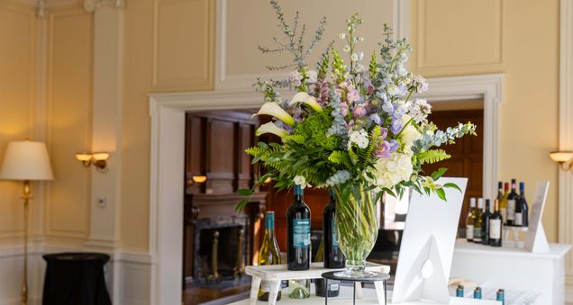 Extravagant floral arrangement atop a wine bar setup in the Living Room.