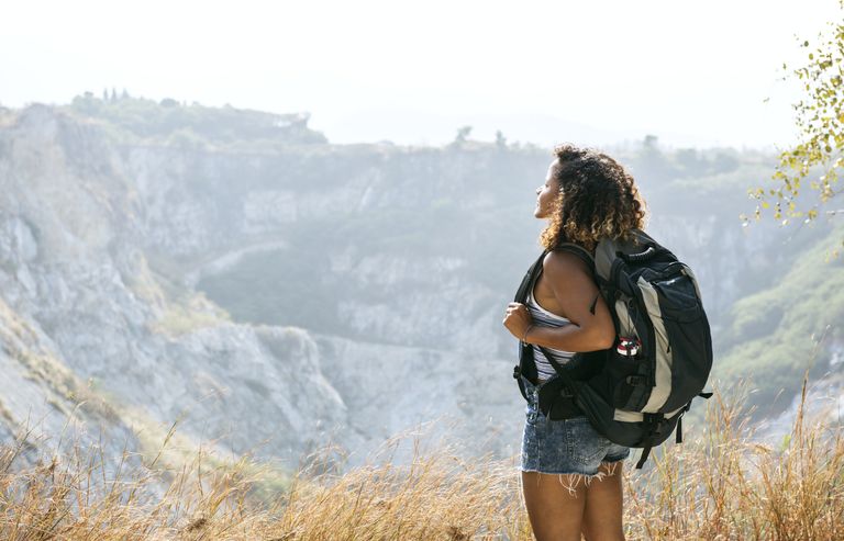 Female with a backpack staring off to the mountain