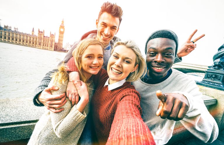 Happy multiracial friends group taking selfie in London