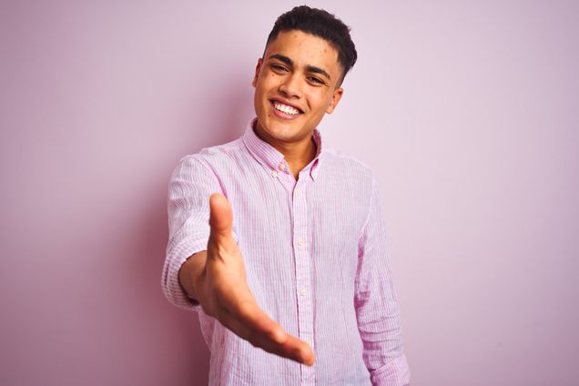 Young brazilian man wearing shirt standing ove