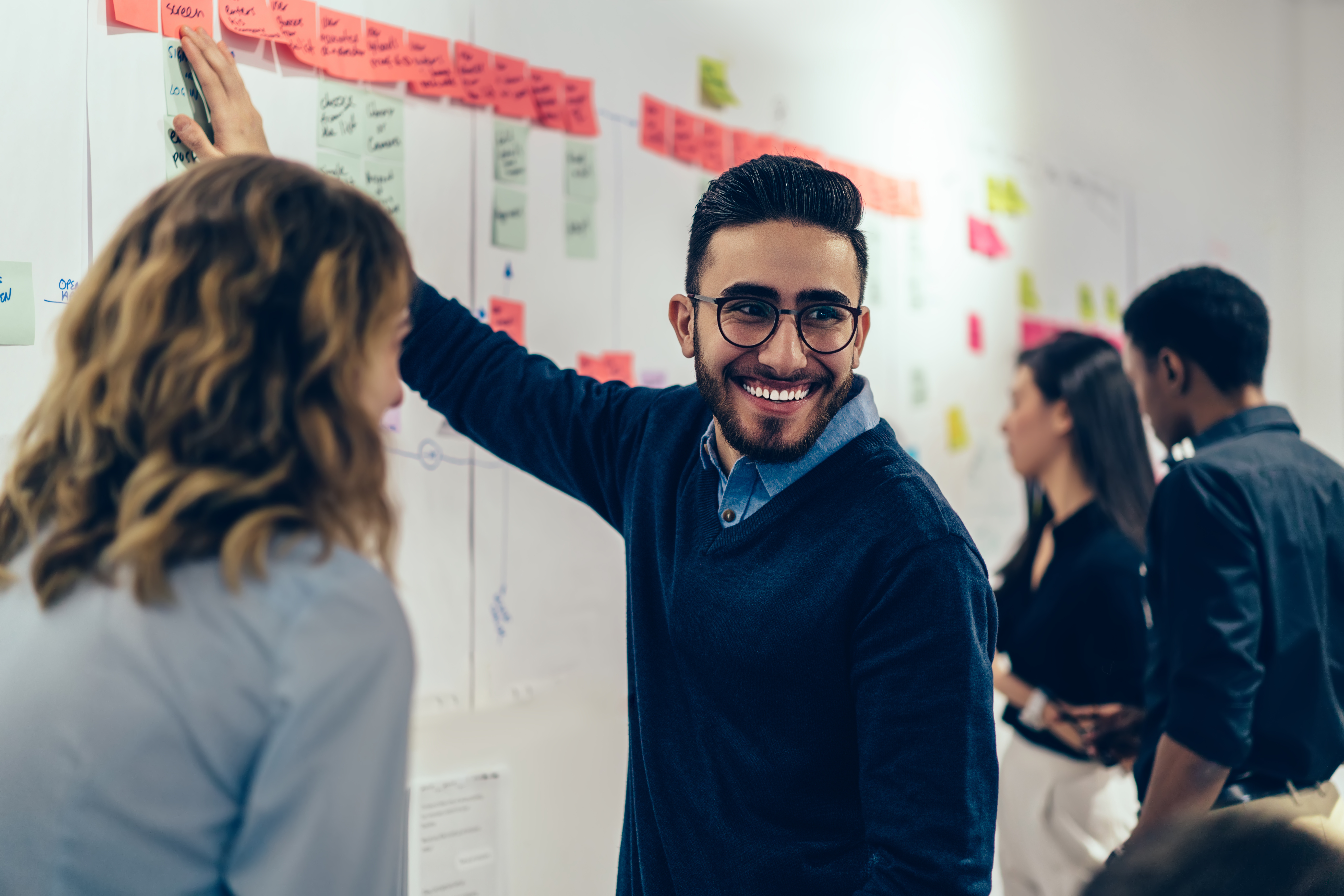 Positive young man laughing while collaboration