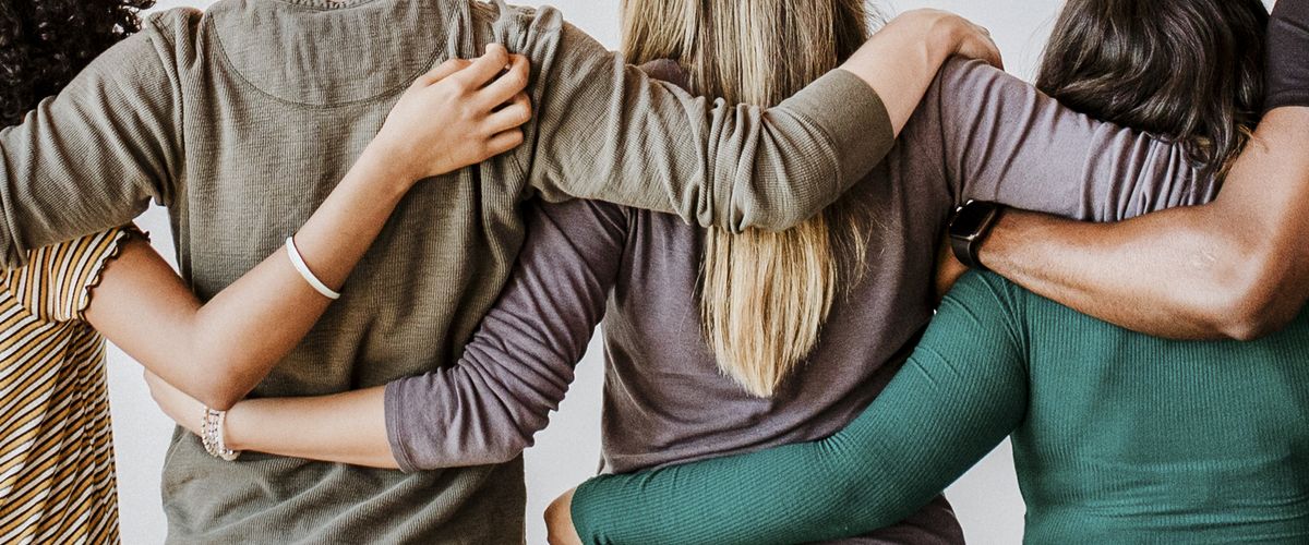 Rearview of diverse people hugging each other